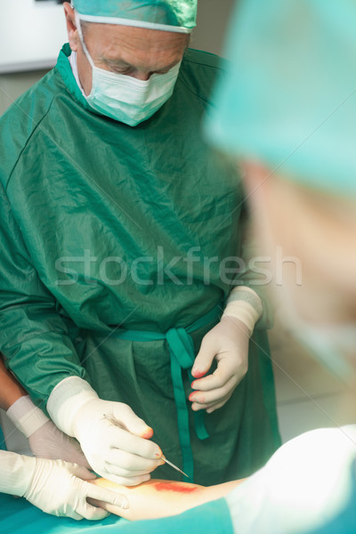 Surgeon using a scalpel to cut the skin of a patient in a surgical room Stock photo © wavebreak_media
