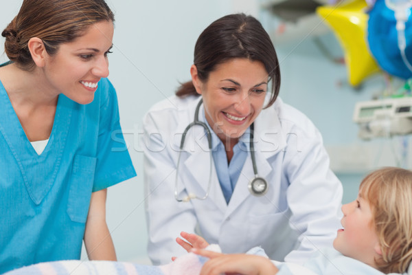Nurse and doctor smiling to a child in hospital ward Stock photo © wavebreak_media