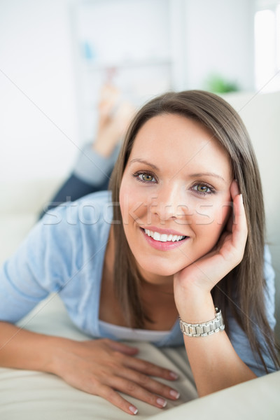 Stock photo: Woman looking happy on sofa in the living room