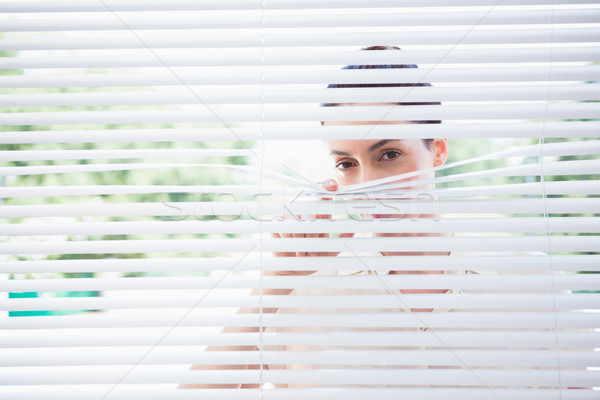 Woman peeking through blinds Stock photo © wavebreak_media