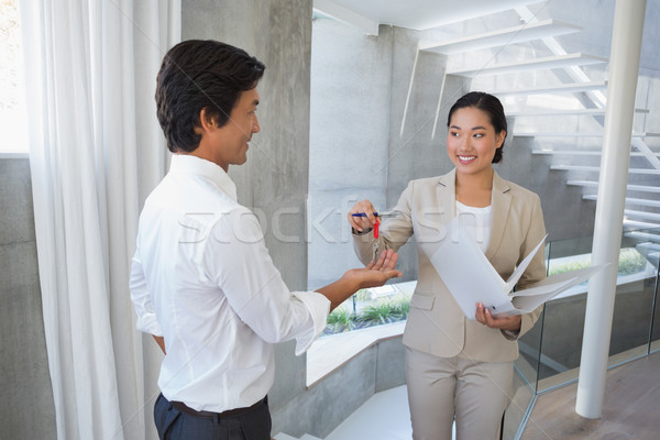 Estate agent giving house key to buyer Stock photo © wavebreak_media