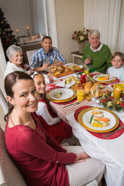 Stock photo: Festive family smiling at camera during christmas dinner