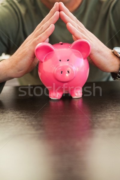 Mid section of a man with joined hands on piggy bank Stock photo © wavebreak_media