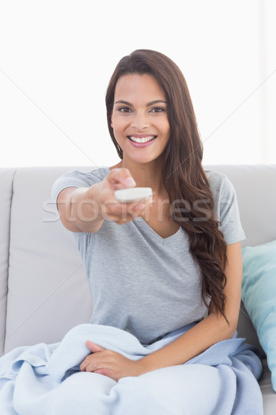 Young woman changing channels on sofa Stock photo © wavebreak_media