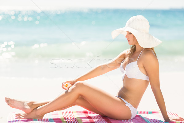 Pretty blonde woman putting sun tan lotion on her leg  Stock photo © wavebreak_media
