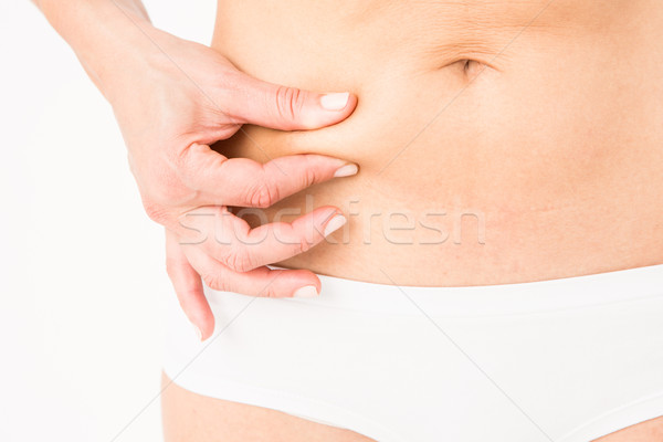 Fit woman pinching her stomach Stock photo © wavebreak_media