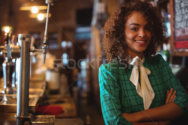 Portret chelneriţă în picioare cu bratele incrucisate contracara pub Imagine de stoc © wavebreak_media