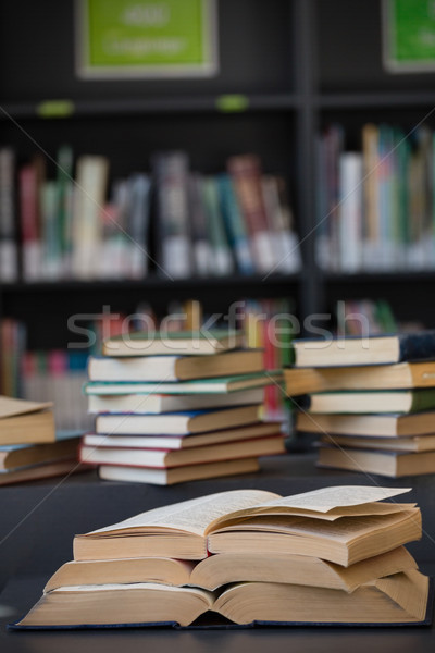 Close up of books stack on table against shelf Stock photo © wavebreak_media