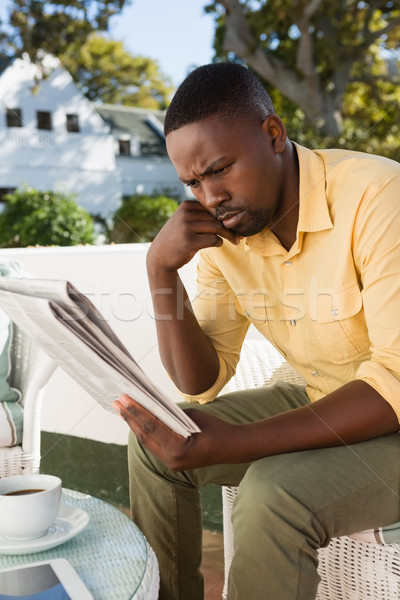 Ernstig jonge man lezing krant cafe vergadering Stockfoto © wavebreak_media