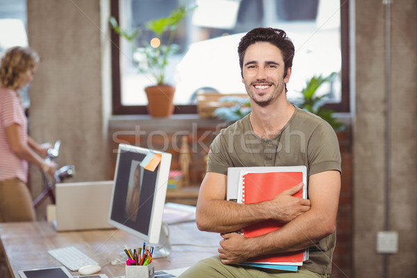 Portrait of smiling businessman holding files and folders in cre Stock photo © wavebreak_media