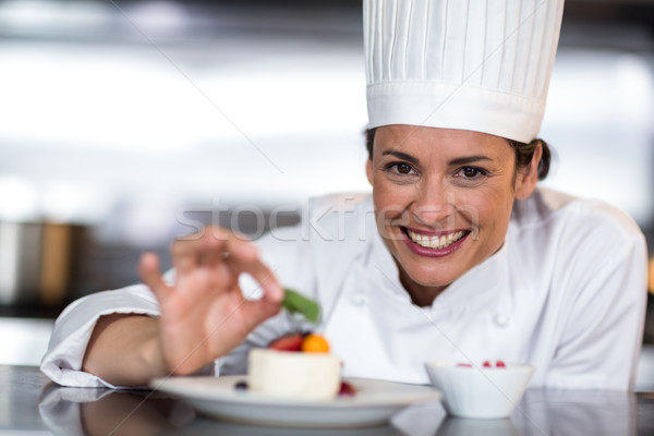 Portrait of happy female chef garnishing on food Stock photo © wavebreak_media