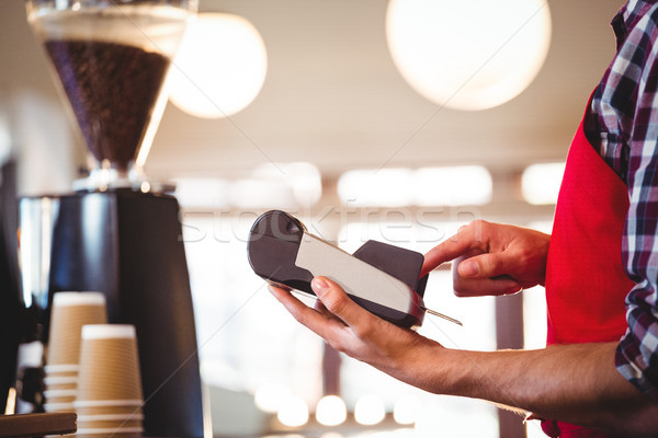 Stock photo: Mid section of waiter using credit card machine