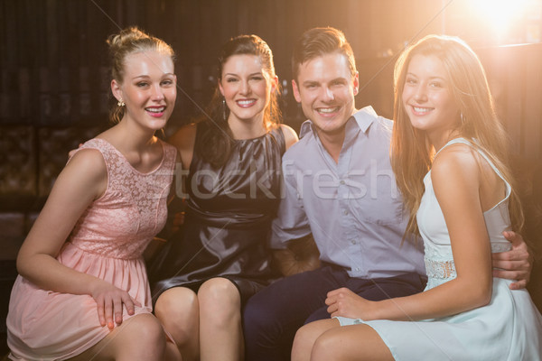 Smiling friends sitting together in sofa at bar Stock photo © wavebreak_media