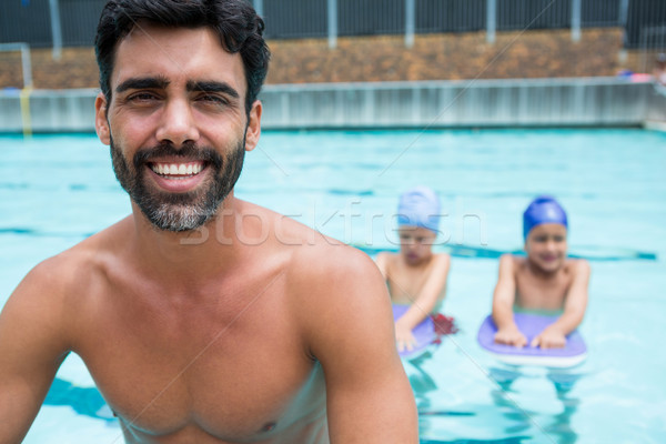 Sonriendo entrenador sesión hombre ninos piscina Foto stock © wavebreak_media