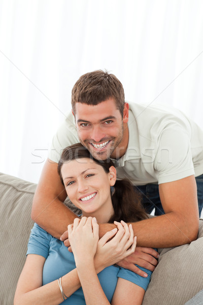 Happy man hugging his girlfriend sitting on the sofa at home Stock photo © wavebreak_media