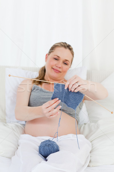 Adorable pregnant woman knitting on her bed at home Stock photo © wavebreak_media