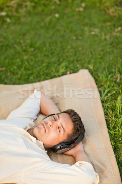 Joven escuchar música parque sonrisa cara hombre Foto stock © wavebreak_media