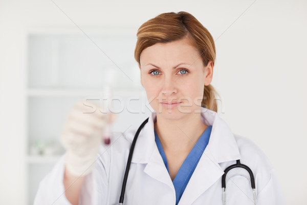 Blond-haired scientist looking at the camera while holding a red test tube in a lab Stock photo © wavebreak_media