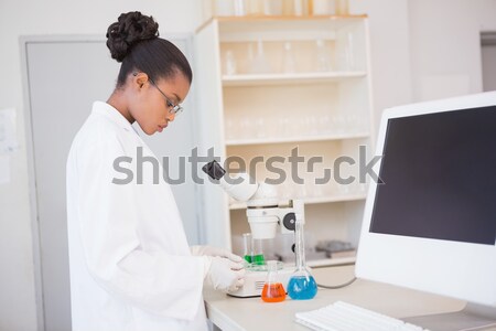 Beautiful red-haired scientist using a pipette in a lab Stock photo © wavebreak_media