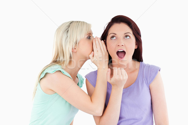 Portrait of a blond woman telling her friend a secret in a studio Stock photo © wavebreak_media