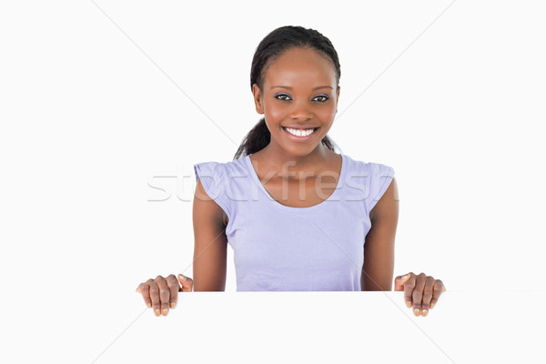 Smiling woman with placeholder in her hands on white background Stock photo © wavebreak_media