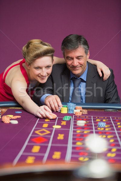Woman placing bet for man at roulette table Stock photo © wavebreak_media