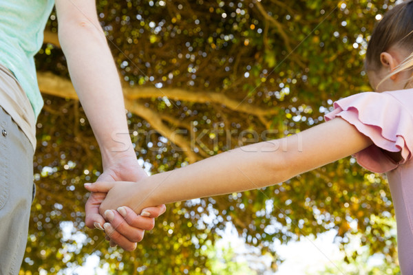 Mother holding a hand of her daughter outdoors Stock photo © wavebreak_media