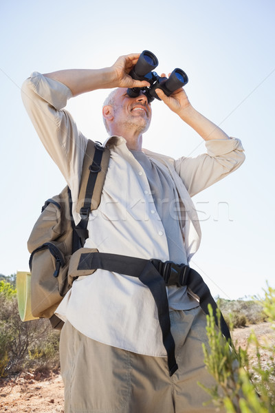 Hiker standing on country trail looking through binoculars Stock photo © wavebreak_media