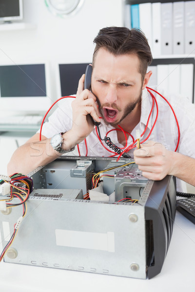 Stock photo: Angry computer engineer making a call