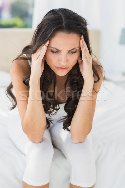Worried brunette sitting on bed Stock photo © wavebreak_media