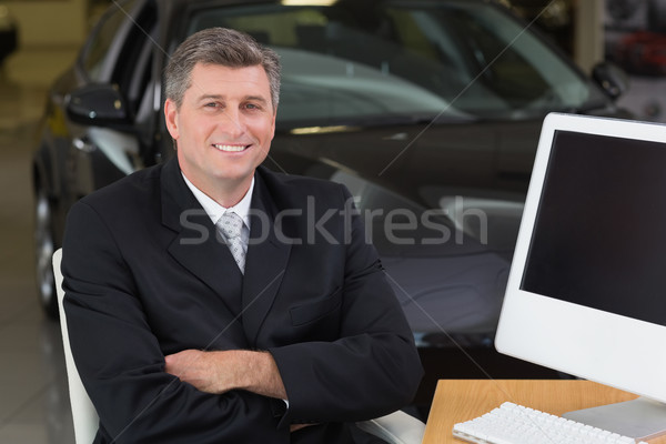 Smiling businessman sitting at his desk with arms crossed Stock photo © wavebreak_media