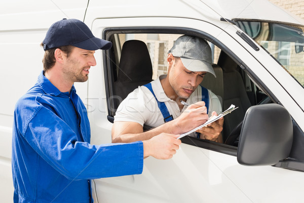 Delivery driver signing on the clipboard Stock photo © wavebreak_media