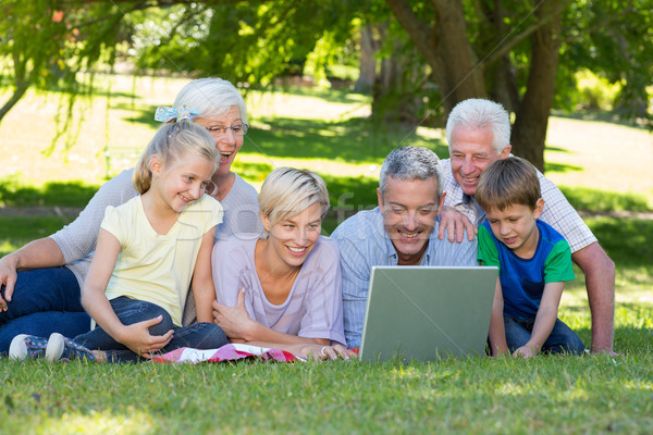 Stock photo: Happy family using laptop in the park 