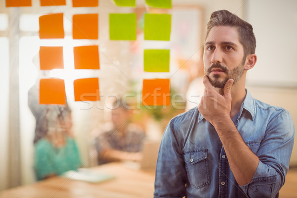 Concentrated businessman looking post its on the wall Stock photo © wavebreak_media