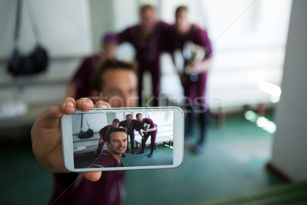 Stock photo: Close up of baseball team clicking selfie while standing at locker room