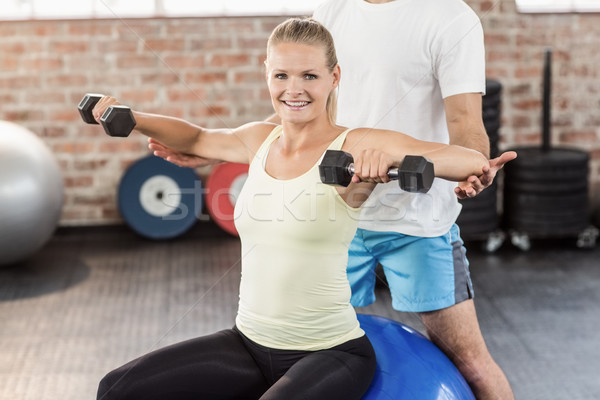 Stock photo: Male trainer helping young woman with the dumbbells 