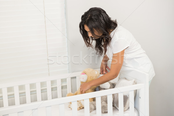 Smiling brunette putting in order the crib Stock photo © wavebreak_media
