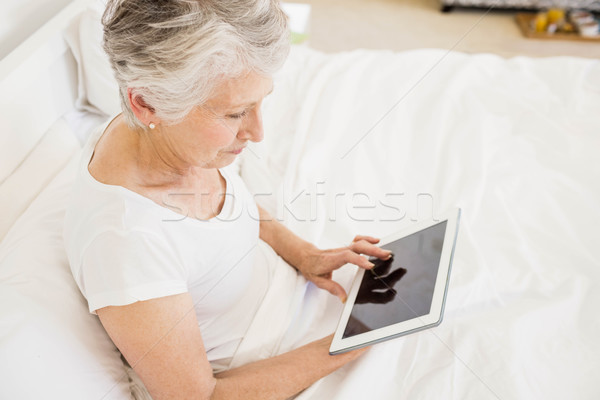 Mujer sonriente tableta sesión cama mujer feliz Foto stock © wavebreak_media