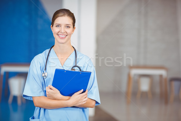 Portrait of beautiful happy female doctor holding clipboard  Stock photo © wavebreak_media