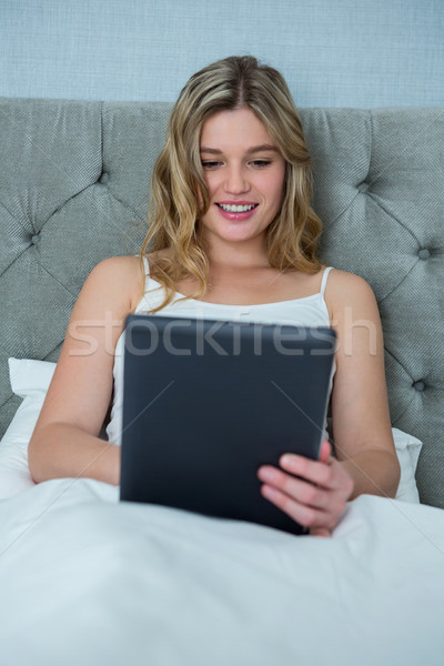 Woman using digital tablet on bed Stock photo © wavebreak_media