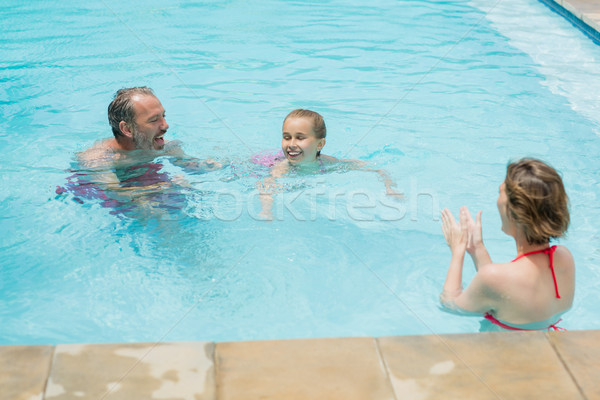 Happy parents and daughter having fun in pool Stock photo © wavebreak_media