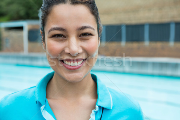 Sorridente feminino treinador em pé piscina aprendizagem Foto stock © wavebreak_media