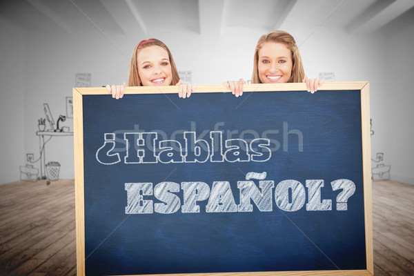 Composite image of close up of young women behind a blank sign Stock photo © wavebreak_media