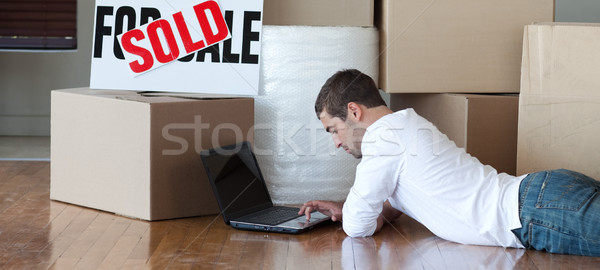 Stock photo: Relaxed man lying on the floor using a laptop