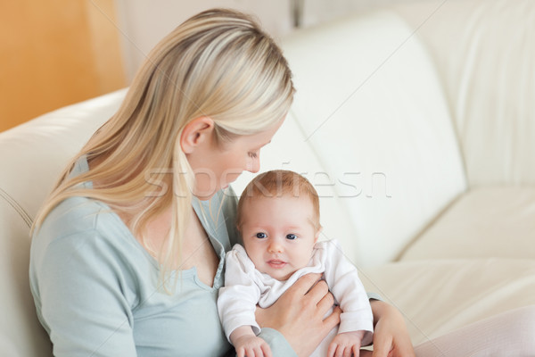Young mother on the sofa with her newborn on her lap Stock photo © wavebreak_media