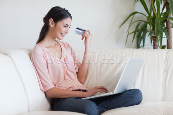 Stock photo: Smiling woman shopping online in her living room
