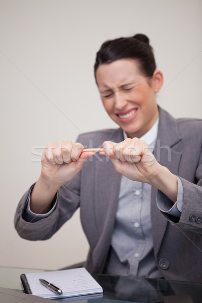 Angry young businesswoman trying to break pencil Stock photo © wavebreak_media