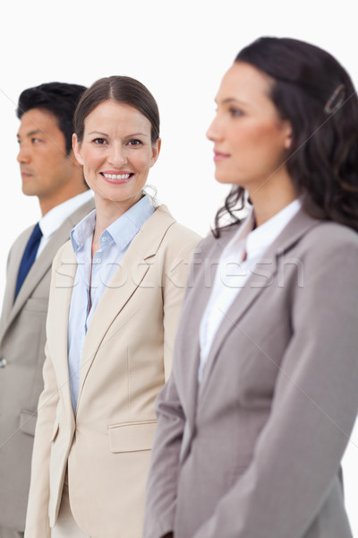 Smiling saleswoman standing between colleagues against a white background Stock photo © wavebreak_media