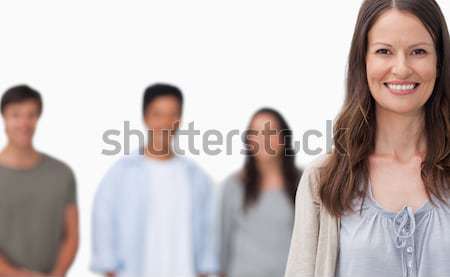 Femeie zambitoare prietenii în picioare in spatele alb fericit Imagine de stoc © wavebreak_media