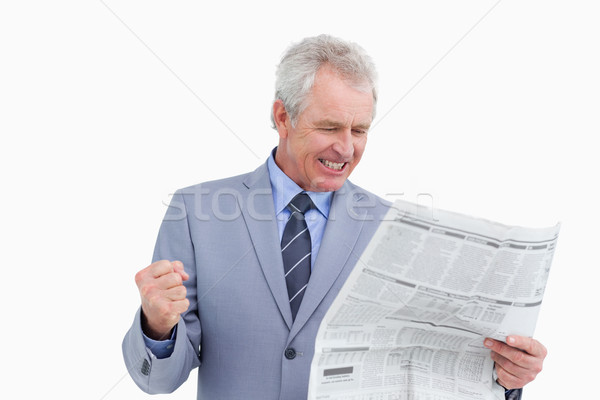 Mature tradesman cheering about news paper article against a white background Stock photo © wavebreak_media
